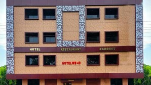 Un edificio de varios pisos con techo plano, que alberga un hotel, restaurante y salones de banquetes.