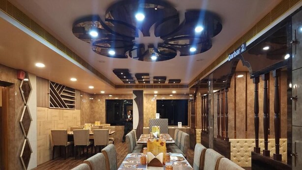 Un restaurante con una larga mesa de comedor preparada para una comida, rodeado de cabinas acolchadas.