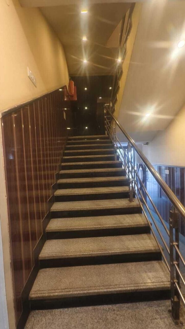 A staircase with carpeted steps and metal railings, leading to an upper floor. - HOTEL WB40 (Durgapur)