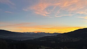 Ett bergigt landskap med en klar himmel under solnedgången.