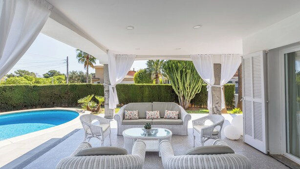 A covered outdoor area with a pool, wicker furniture, and a sofa with cushions. - Can Pedro, elegant villa in Llenaire 3 min walk from the beach! (Port de Pollença)