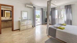 A modern hotel room with a large bed, a vanity with a mirror, a sink, and a view of the outdoors. - Can Pedro, elegant villa in Llenaire 3 min walk from the beach! (Port de Pollença)