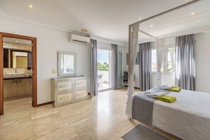 A modern hotel room with a large bed, a vanity with a mirror, a sink, and a view of the outdoors. - Can Pedro, elegant villa in Llenaire 3 min walk from the beach! (Port de Pollença)