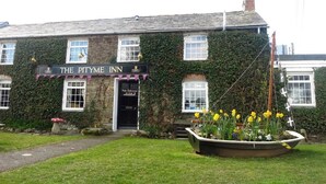 A traditional building with ivy-covered walls and a sign reading "The Pitme Inn". - Pityme Inn (Wadebridge)