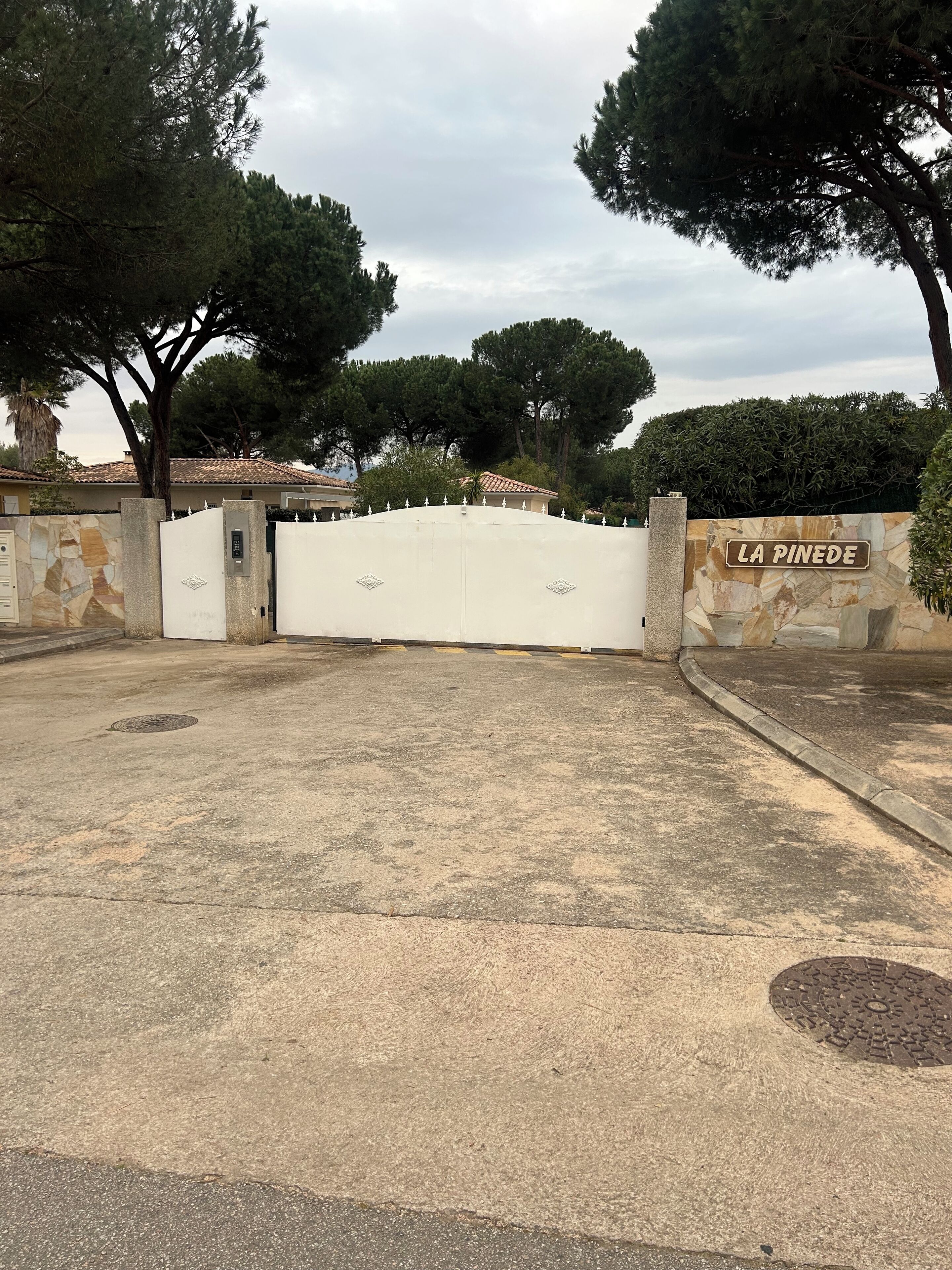 Una entrada cerrada con un letrero que dice "LA PINEDE".