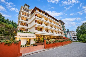 Ein mehrstöckiges Hotel mit einem markanten Eingang, Balkonen und blauem Himmel.