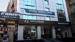 Rakennuksessa on kyltti, jossa lukee «Stellar Smiles Clinic» ja «Concept Hyundai», ja kyltit ovat sijoitettu rakennuksen ensimmäiseen kerrokseen.
