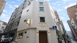 Um hotel com design moderno, destacando uma entrada imponente e sinalização.