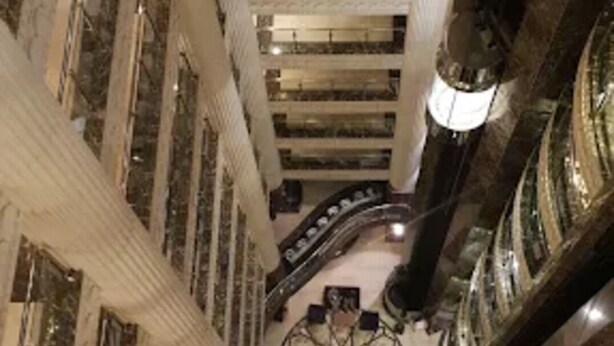 A high-ceilinged atrium with marble floors and a central circular design.