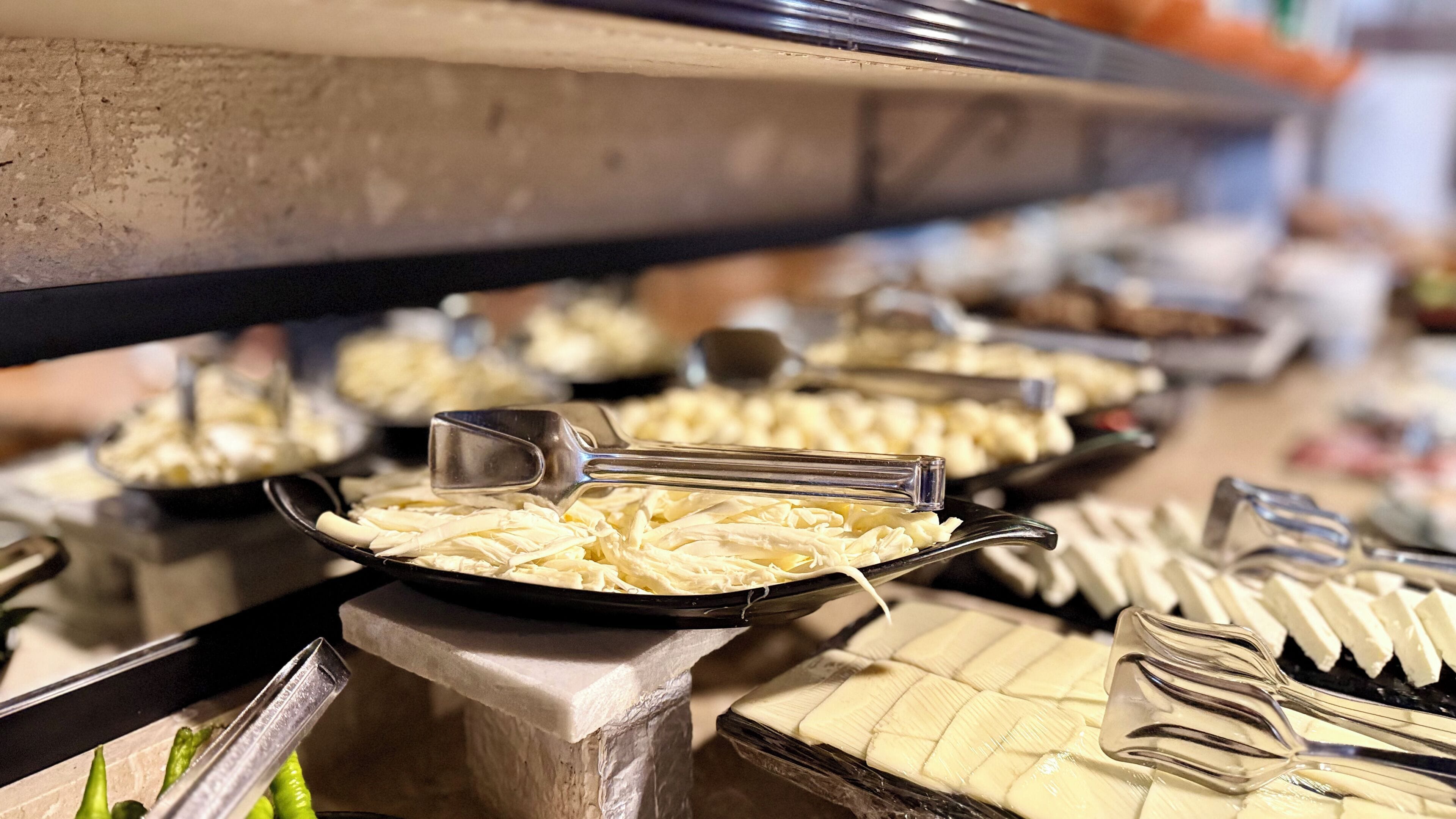 Ein Buffet mit verschiedenen Speisen, darunter Käse und weitere Gerichte.