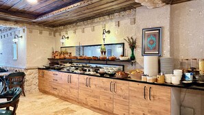 A buffet area with a wooden counter, various food items, and decorative elements like vases and wall art. - Bloom Cappadocia Hotel (Nevsehir)