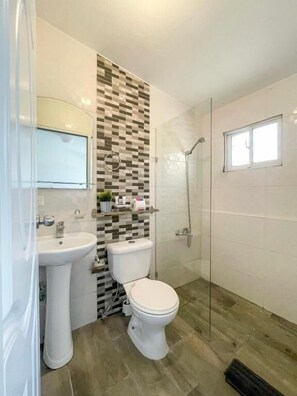 Departamento básico, 1 cama Queen size, cocina, vista a la ciudad | Baño | Regadera, toallas, jabón, papel de baño 