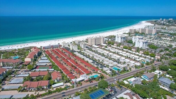 Vista aérea de una zona costera con playa, hoteles y una carretera.