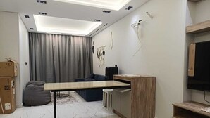 Un salon moderne avec un canapé, une table basse et un téléviseur.