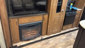 A kitchen with wooden cabinets, a large black stove, and a built-in oven. - Cozy 1-bedroom caravan in lovely Aiken with AC (Aiken)