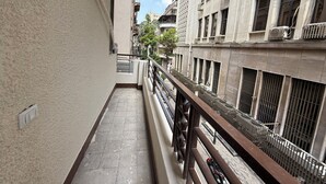 A narrow corridor with a tiled floor, a metal railing, and a view of adjacent buildings. - La Casa del Centro Cairo (Cairo)