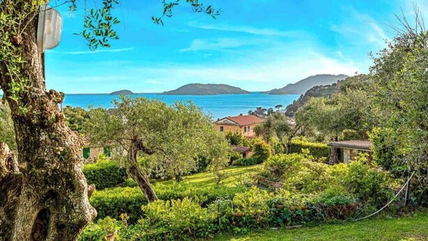 A lush garden with a view of the sea and hills in the background. - ‘La Tuile’ in Lerici, a hidden gem that promises an unforgettable experience with breathtaking sea views. This exclusive penthouse, located in a privileged position, invites you to experience moments of pure relaxation and tranquillity in its idyllic (Lerici)
