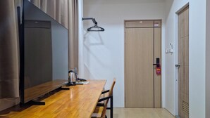 A modern room with a wooden table, chairs, a TV, and a door.