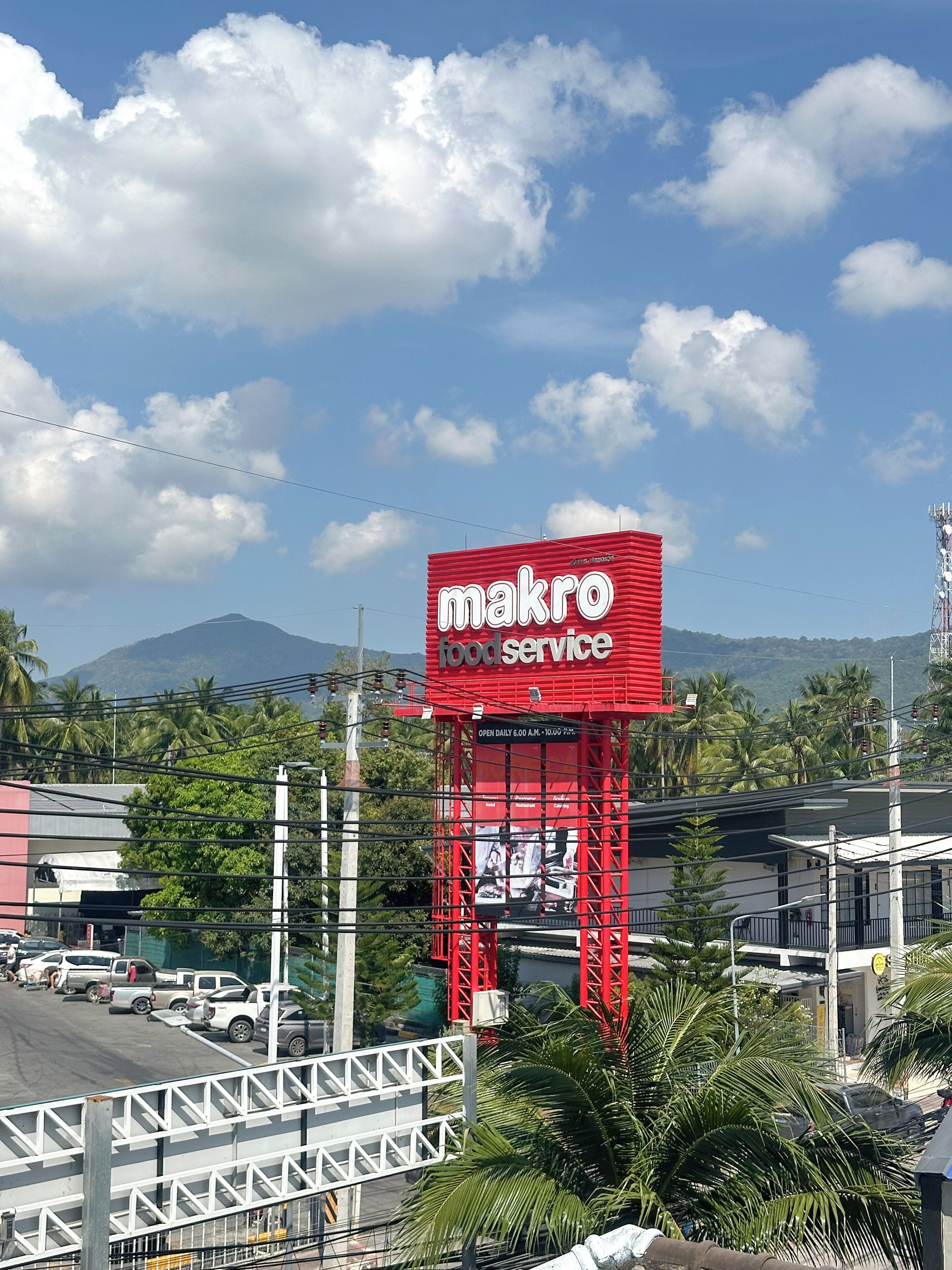 A red billboard advertising a food service with a mountain in the background.