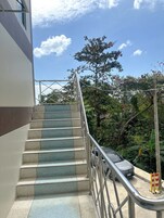 A set of outdoor stairs with metal railings, leading up to a building.