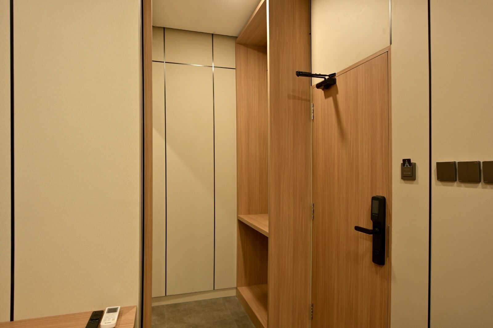Un closet amplio con puertas de madera, un estante pequeño y un candado digital.