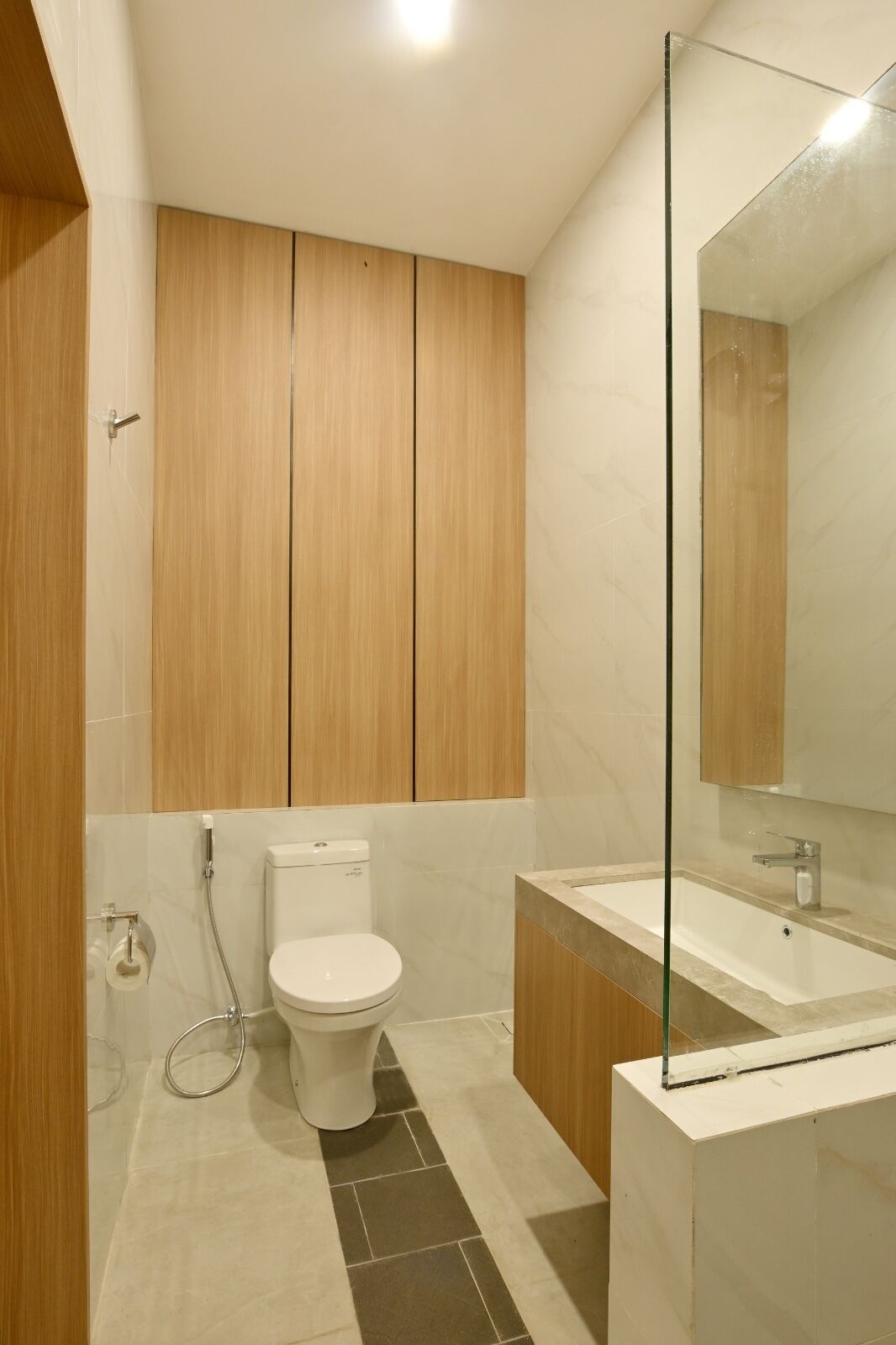 Une salle de bain moderne équipée de toilettes, d’une douche et d’un lavabo.