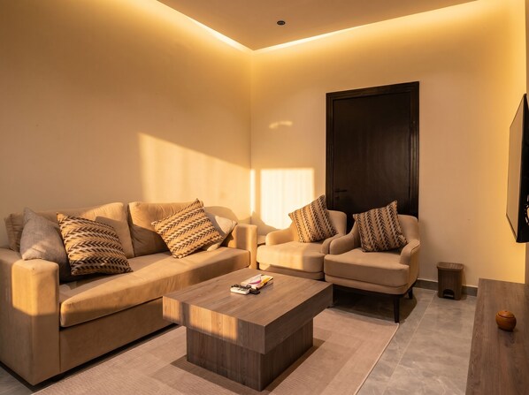 A modern living room with two sofas, a coffee table, and a TV mounted on the wall. - Vinas Riyadh Serviced Apartments (Riyadh)
