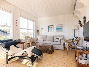 A cozy living room with a sofa, chairs, a coffee table, and a TV. - 4 Star Holiday Home in Skagen (Skagen)