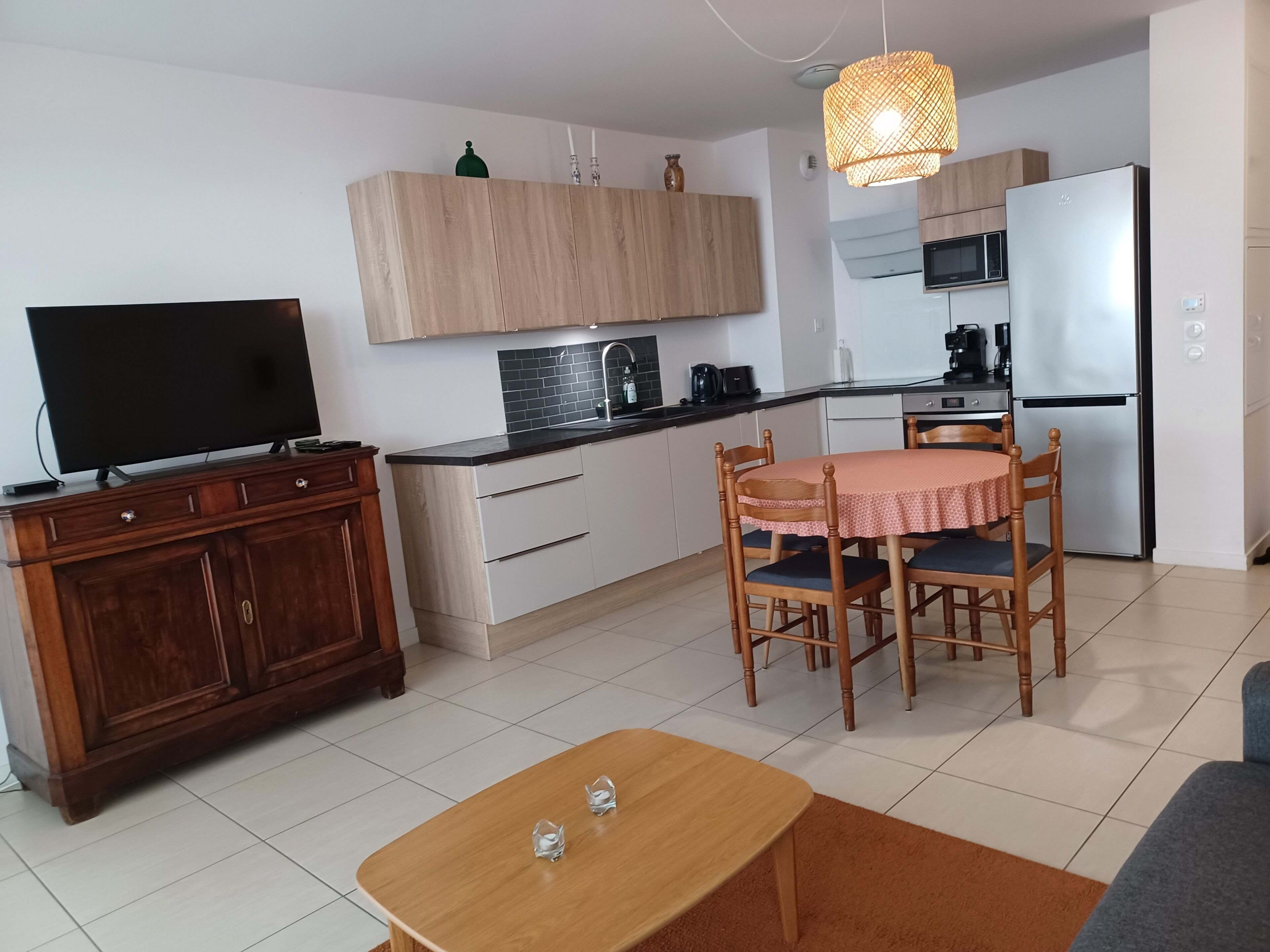Una cocina moderna con comedor, televisión y sofá.