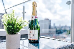 A bottle of champagne on a balcony with a city view. - Premium City Penthouse Ideal For Business (Leeds)