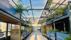 A covered walkway with metal railings and potted plants. - Buho Urban Curic A C Washer Dryer Wifi (Santiago)