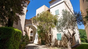 A pathway leading to a building with arches and a tree-lined entrance. - Les Rivages de Coudoulière by Interhome (Six Fours La Coudoulière)