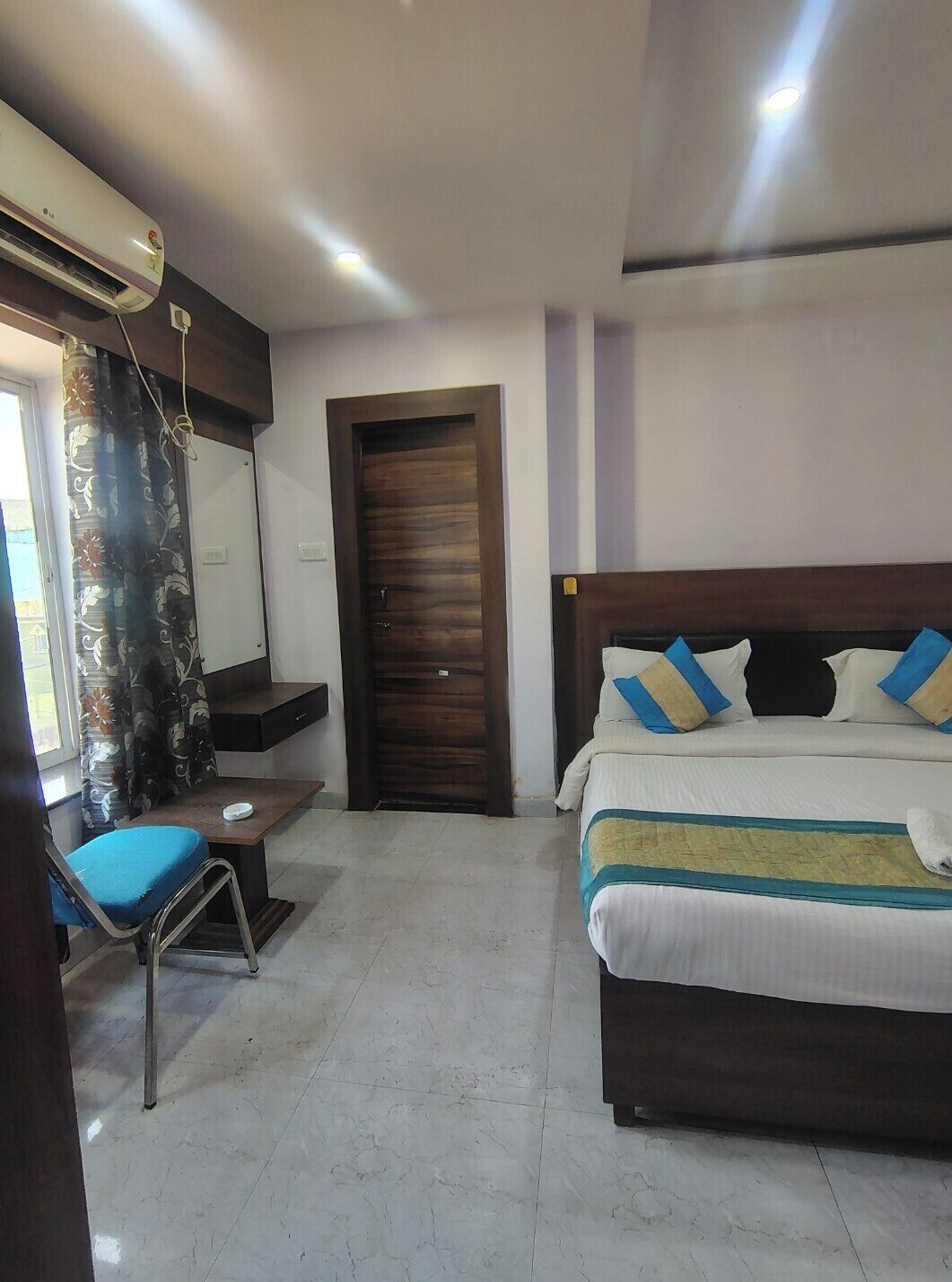 Une chambre d’hôtel comprenant un lit, un bureau, une chaise, une armoire et une porte.