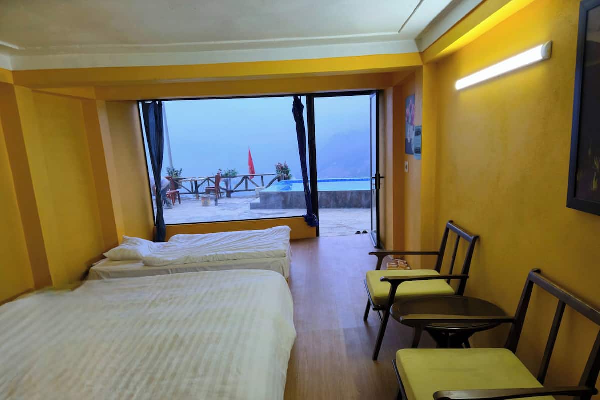 Une chambre d’hôtel avec deux lits, une petite table et une chaise.