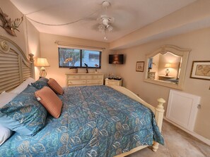 A bedroom with a large bed, a dresser, a television, and a ceiling fan. - Vacation in the picturesque, waterfront Isla Del Sol community of Bahia (St. Petersburg)