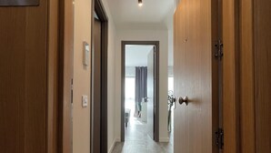 A hallway with wooden doors, a number plate, and a light fixture. - Parcului20 Apart near Romexpo, Herastrau Park (București)