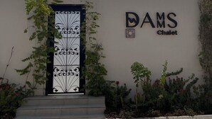 A building with a sign reading "DAMS Chalet" and a decorative gate. - Serene 1-bedroom chalet with Pool and Water play in charming Diriyah (Diriyah)