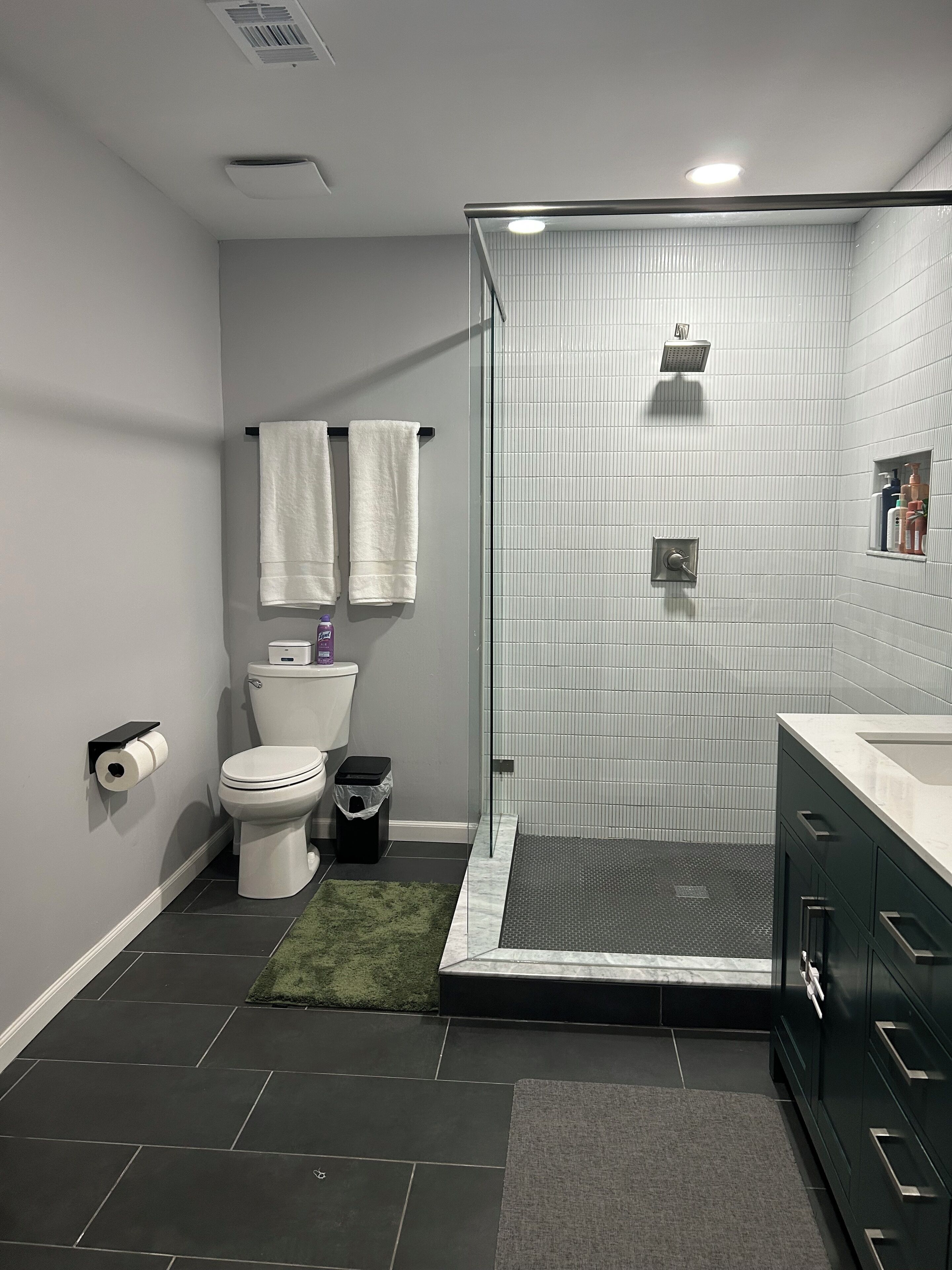 A modern bathroom with a toilet, bidet, and shower.