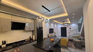 A modern kitchen with a central island, built-in appliances, and a dining area with a sofa and bar stools. - East Legon Hills, Accra, Nanakrom Gated Community (Accra)