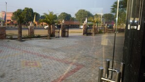 A paved courtyard with a patterned floor, metal gates, and trees. - Eco Fort Resort (Mahwah)
