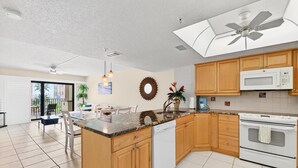 Una cocina moderna con armarios de madera, lavavajillas blanco y un microondas.
