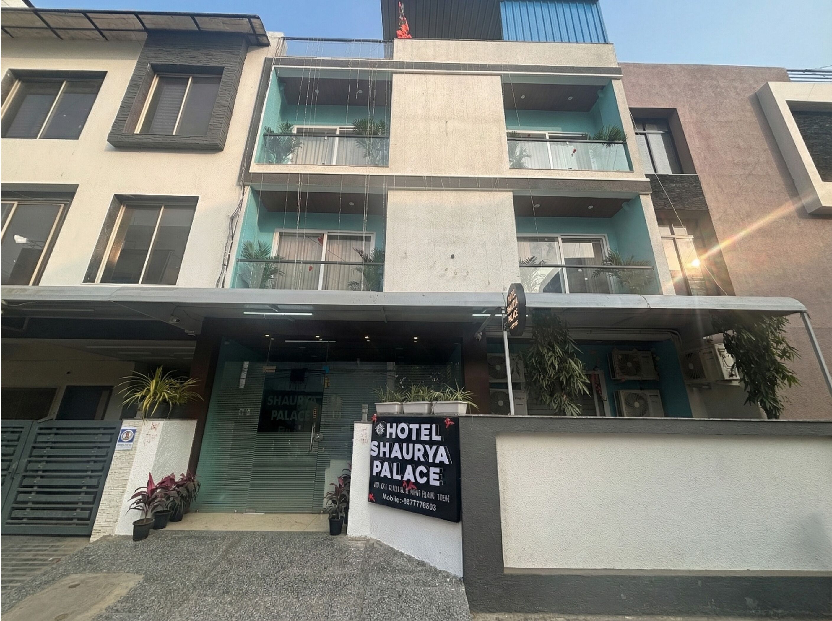 A multi-story hotel with balconies and a sign for 'Hotel Shaurya Palace'.