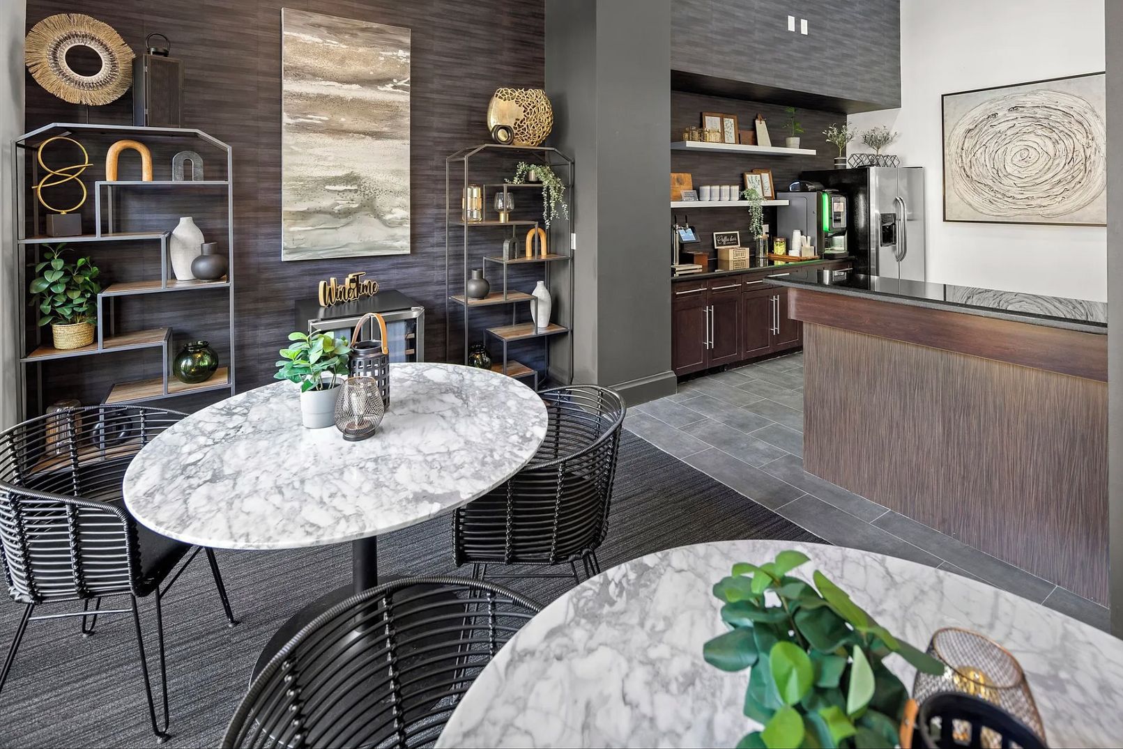 Una cocina moderna con gabinetes de madera oscura, encimera de mármol y horno empotrado.