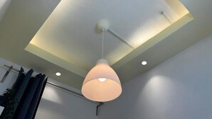 Un plafond doté d’un éclairage encastré et d’un luminaire suspendu.