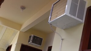 Fachada de un edificio con una puerta, una ventana y un equipo de aire acondicionado montado en la pared.