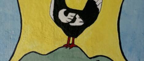 Ein Wappen mit einem Hahn und einem Fisch, mit der Aufschrift „FISCHBACH Thüringen“.