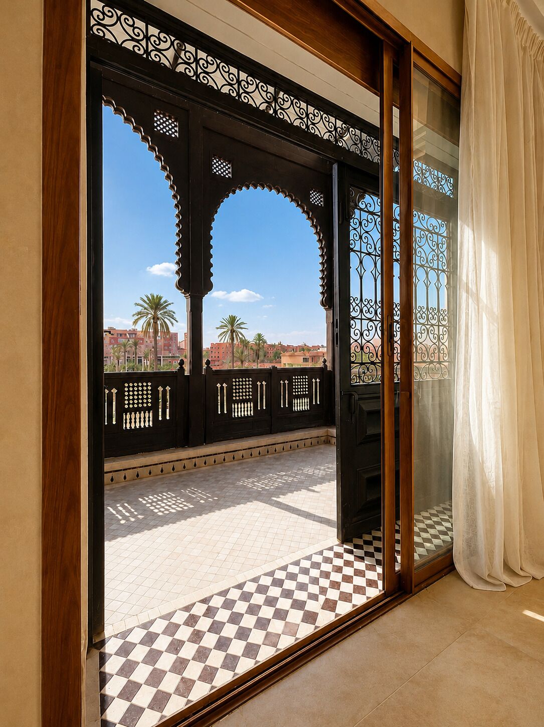 A room with a view of palm trees and buildings, a checkered floor, and a decorative black metal gate.