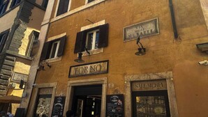 Ein Gebäude mit mehreren Schildern, darunter 'VIA DELLE MURATTE' und 'SALUMIDERIA'.