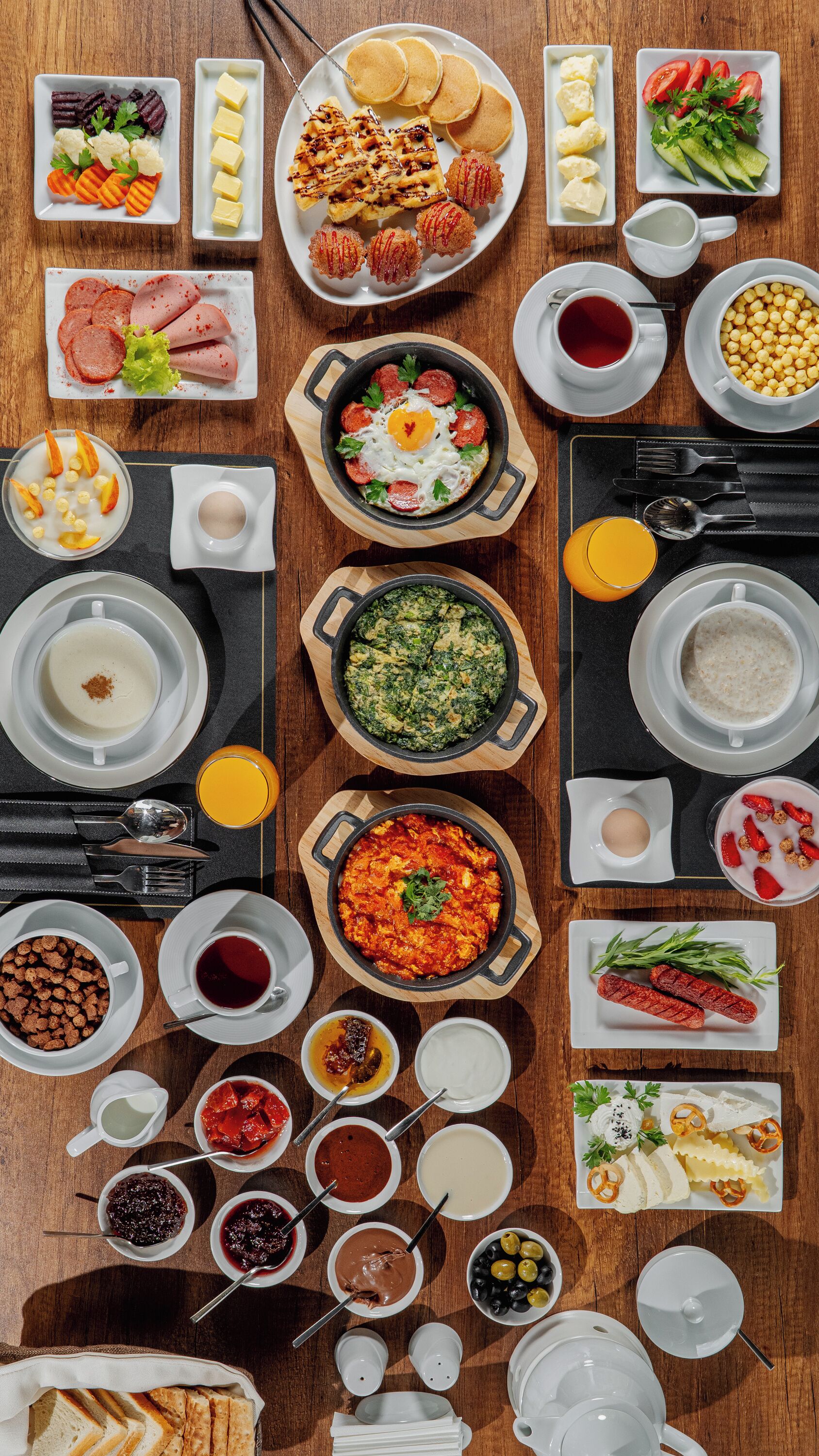 Une variété de plats et de boissons pour le petit-déjeuner, disposés sur une table en bois.