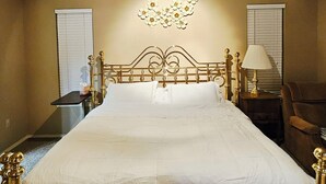 Un dormitorio con una cama grande, un ventilador de techo y un adorno en la pared.